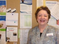 february-2012-spotlight-volunteer-joanna-martens-poses-next-to-her-store's-wellness-board
